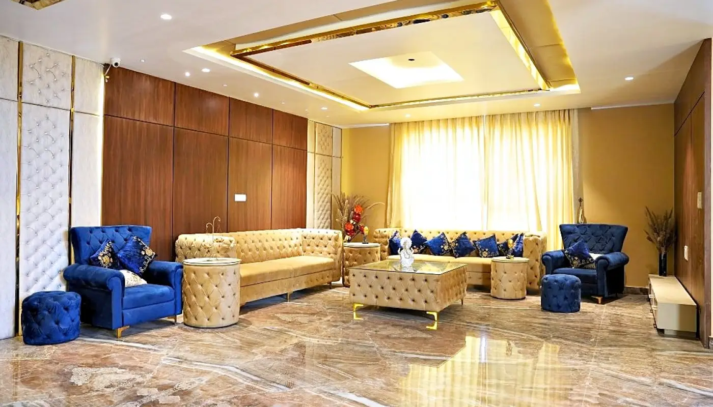 Main living hall with blue velvet seating, marble floor and a coffered ceiling